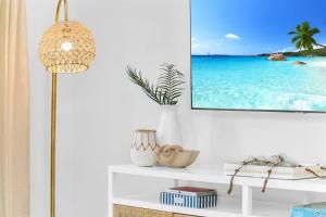 a living room with a tv on a wall at ON The Beach Juno! 3-Top Rated Villa! in Juno Beach