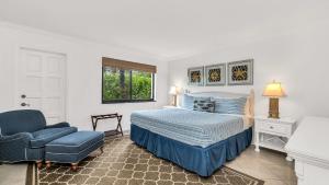 a bedroom with a bed and a blue chair at ON The Beach Juno! Modern Lux Seaside! in Juno Beach