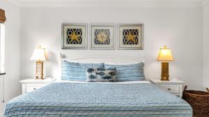 a bedroom with a blue bed with two lamps at ON The Beach Juno! Modern Lux Seaside! in Juno Beach +25 photos