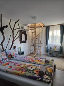 a bedroom with a large bed with a tree on the wall at La Moșie in Săldăbagiu de Munte