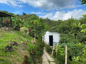 a white building with a door in a garden at la samara in Anapoima