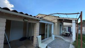 a house with a patio with a table and chairs at MAISON AVIGNON 4P avec piscine in Avignon