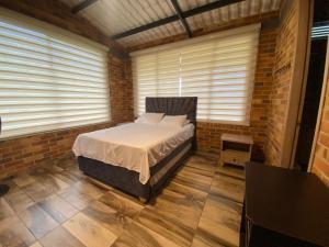 a bedroom with a bed in a brick wall at la samara in Anapoima +28 photos
