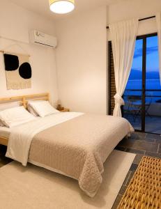 a bedroom with a bed with a view of the ocean at SeaTerra Boutique suite in Kalamos