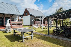a ping pong table in front of a house at Domki Anchor - Rodzinne Domki - Cisza i Spokój in Lubiatowo