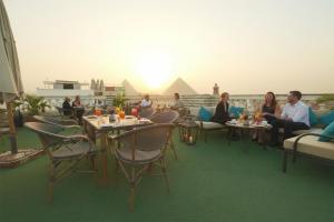 a group of people sitting at tables on a roof at Magic pyramids star hotel in Cairo +54 photos