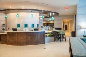 a bar in a restaurant with a counter and chairs at Hyatt Place West Palm Beach in West Palm Beach
