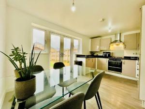 a dining room with a glass table and chairs at MK WhiteHouse cottage in Milton Keynes
