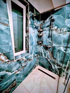 a bathroom with a shower with a marble wall at Ana Residence in Timişoara