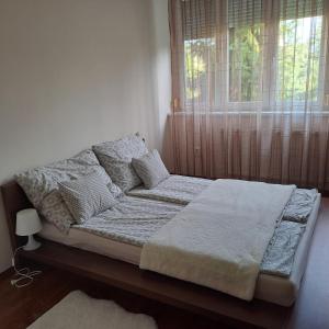 a bed sitting in a bedroom with a window at Citadella apartman in Pusztavacs