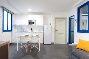 Suites Apartamento 17 في لاس بالماس دي غران كاناريا: مطبخ وغرفة معيشة مع طاولة وكراسي