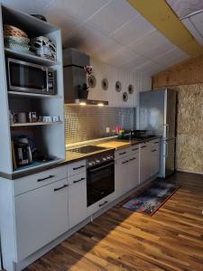 a kitchen with white cabinets and a stove top oven at Ambiente in Emmetten in Emmetten