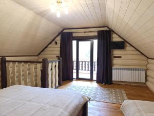 a attic bedroom with a bed and a window at Тихий світанок in Synevyrsʼka Polyana