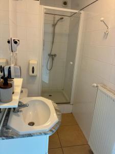 a white bathroom with a shower and a sink at Clos fleury in Cluny
