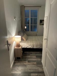 a small bedroom with a bed and a window at Clos fleury in Cluny