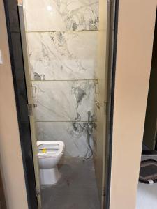a bathroom with a toilet and a marble wall at Ramona homestay in Kolhapur +16 photos