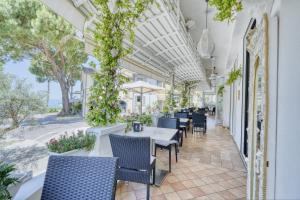 a restaurant with tables and chairs and plants at Hotel Everest - Bar e Ristorante in Gabicce Mare