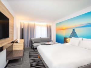 a hotel room with a large bed and a couch at Hotel Novotel Brussels Off Grand Place in Brussels +182 photos