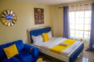 a bedroom with a blue bed and a blue couch at BA STADEVIEW WEST STUDIOs in Nairobi