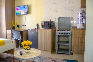 a small kitchen with a stove and a tv at BA STADEVIEW WEST STUDIOs in Nairobi