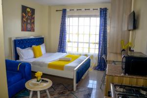 a small bedroom with a bed and a blue couch at BA STADEVIEW WEST STUDIOs in Nairobi