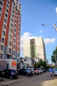a street with cars parked in front of tall buildings at BA STADEVIEW WEST STUDIOs in Nairobi
