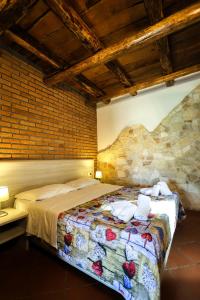 a bedroom with a bed and a stone wall at VILLA MARIA ELENA Charme Rooms sul mare in Capo Vaticano