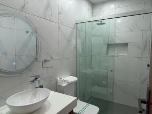 a bathroom with a sink and a glass shower at Hotel Victoria Plaza in Tarija
