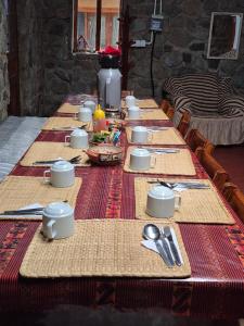 ein langer Tisch mit Tellern und Besteck darauf in der Unterkunft Nacho's hotel in Soray + 44 Fotos