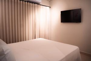 a bedroom with a bed and a television on a wall at You Smart Flats - Hotel in Formosa