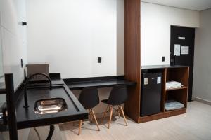 a room with a black desk and chairs in it at You Smart Flats - Hotel in Formosa