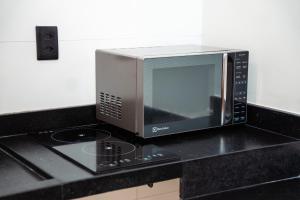 a microwave sitting on top of a kitchen counter at You Smart Flats - Hotel in Formosa +58 photos