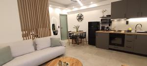 a living room with a white couch and a kitchen at Th Tsimas Luxury studio 4 in Skala Potamias