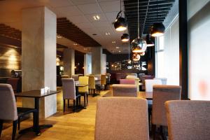 a dining room with chairs and tables and a bar at Fosshótel Rauðará in Reykjavík