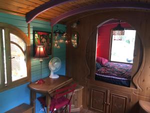 a room with a bed and a table and chairs at La Roulotte du Fier in Annecy