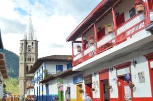 una calle con edificios coloridos y una iglesia en Hotel La Casona en Jardín