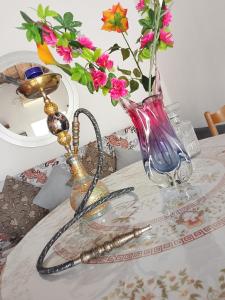 a glass table with a vase with flowers in it at sevas'view in Émbonas