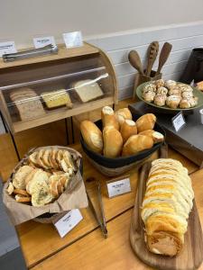 a table with various types of bread and pastries at Sense Hotel Araucária in Araucária