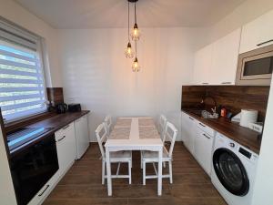 a kitchen with a table and a washing machine at Argent apartman in Balatonmáriafürdő