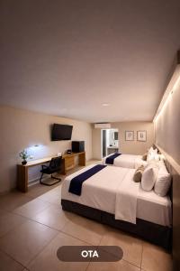 a hotel room with two beds and a desk at HOTEL LOS ROBLES in Nuevo Laredo