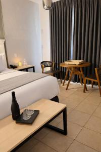 a hotel room with a bed and tables and curtains at HOTEL LOS ROBLES in Nuevo Laredo