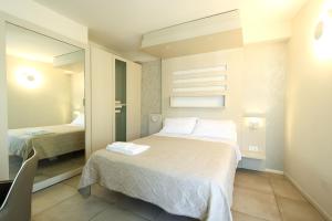 a small bedroom with a bed and a mirror at Chez Moi Tropea Centro in Tropea