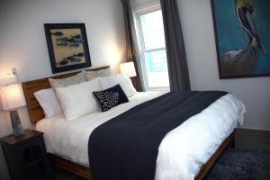 a bedroom with a large bed with pillows and a window at The Pelican Pass in Freeport