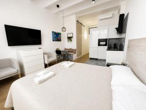 a white bedroom with a bed and a living room at A H Rentals Monet estudio in Vinarós