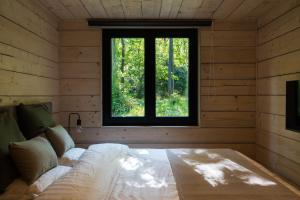 a bedroom with a bed in a room with a window at Wood Chalet Durbuy in Durbuy