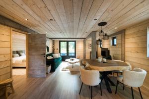 a dining room with a table and a bedroom at Wood Chalet Durbuy in Durbuy