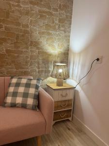 a lamp on a night stand next to a couch at El Olivo Verde 2 in Jaén +1 photo