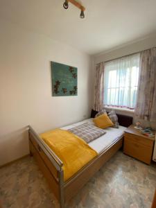 a bedroom with a bed with a yellow blanket on it at Ferienwohnung Abendsonne in Schenkenfelden