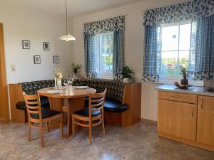 a dining room with a table and chairs in a kitchen at Ferienwohnung Abendsonne in Schenkenfelden