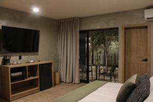 a bedroom with a bed and a television and a balcony at Sweven Hotel Boutique in Guadalajara